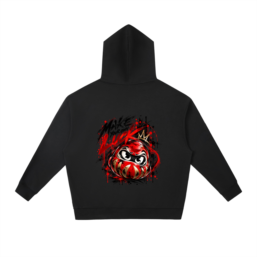 Black oversized hoodie featuring a colorful Daruma design on the back with "MAKE YOUR OWN LUCK" in bold lettering.