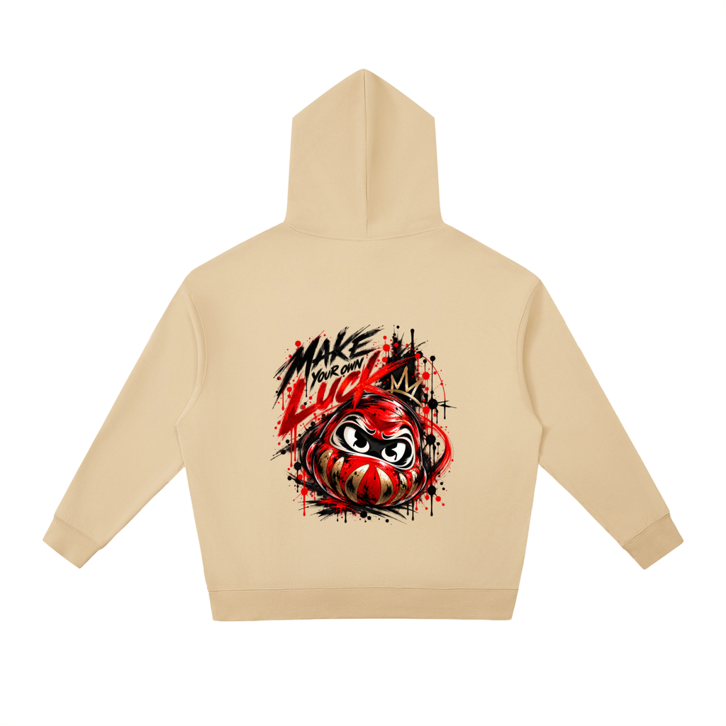 Beige unisex hoodie with a relaxed fit and drop shoulders. Features a graphic of a Daruma doll and "MAKE YOUR OWN LUCK" design on the back.