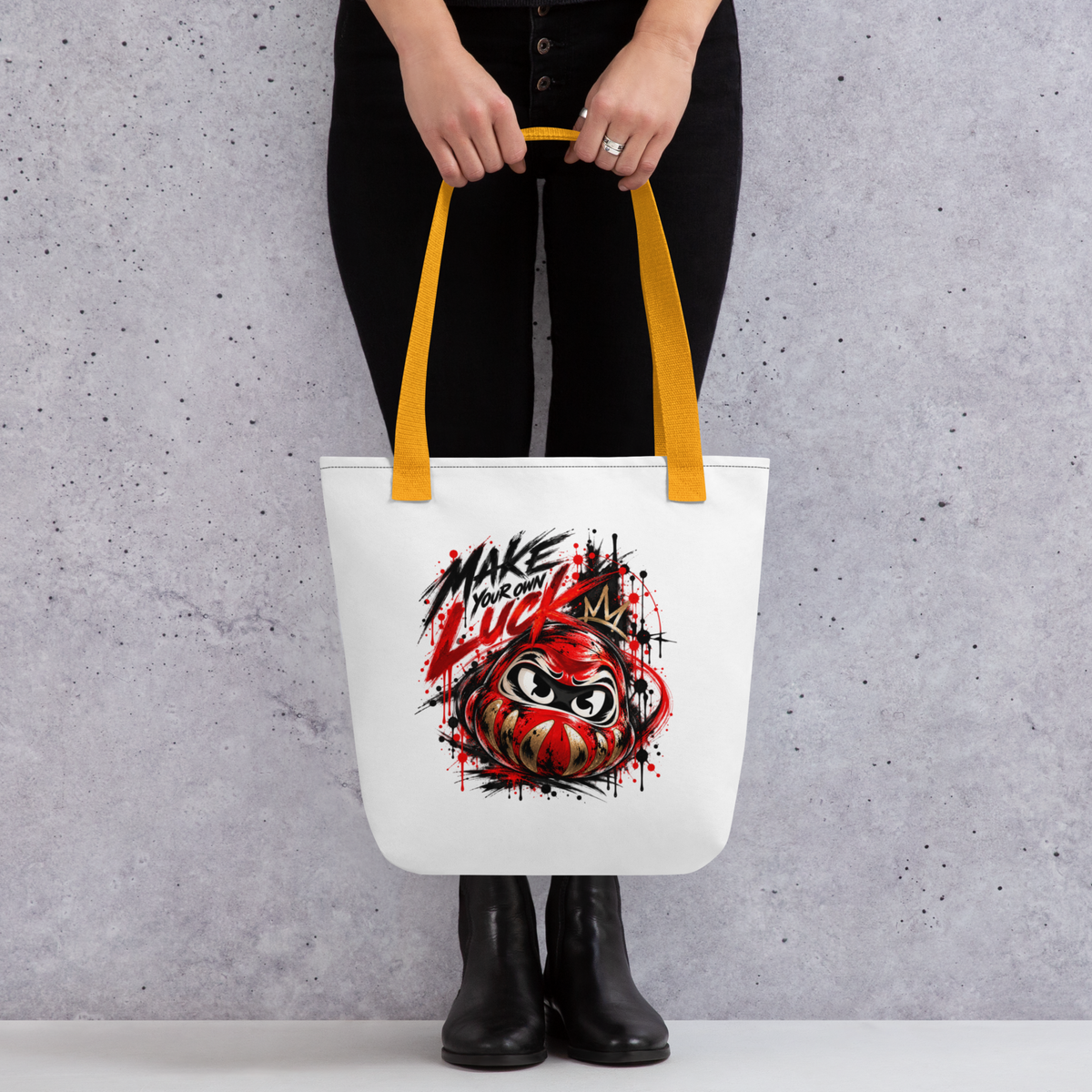 Spacious white tote bag with a colorful Daruma graphic and "Make Your Own Luck" text, featuring yellow handles.